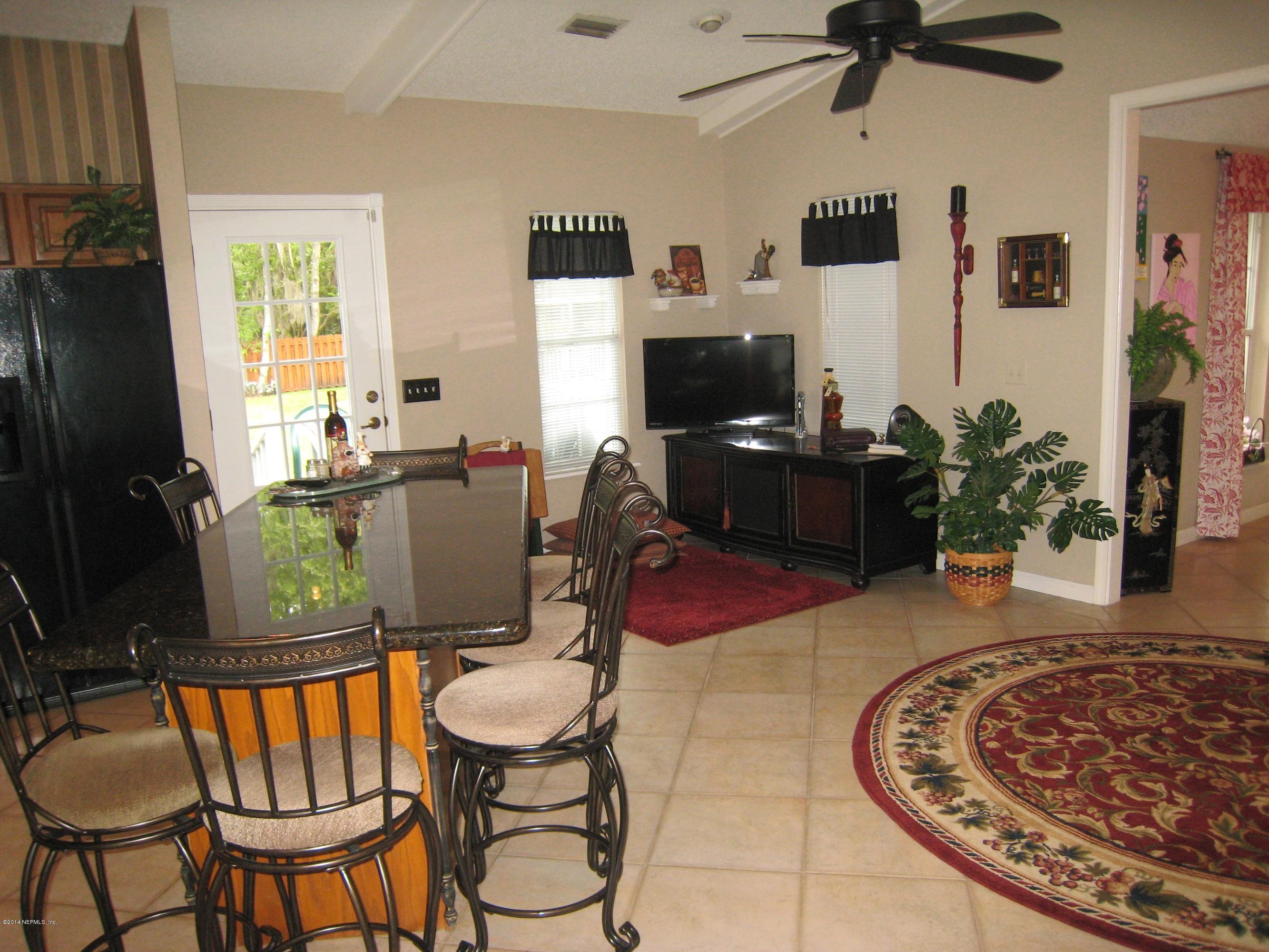11636 Mandarin Road Jacksonville, FL 32223 - Photo 14 of 41 a living room with furniture a flat screen tv and a window