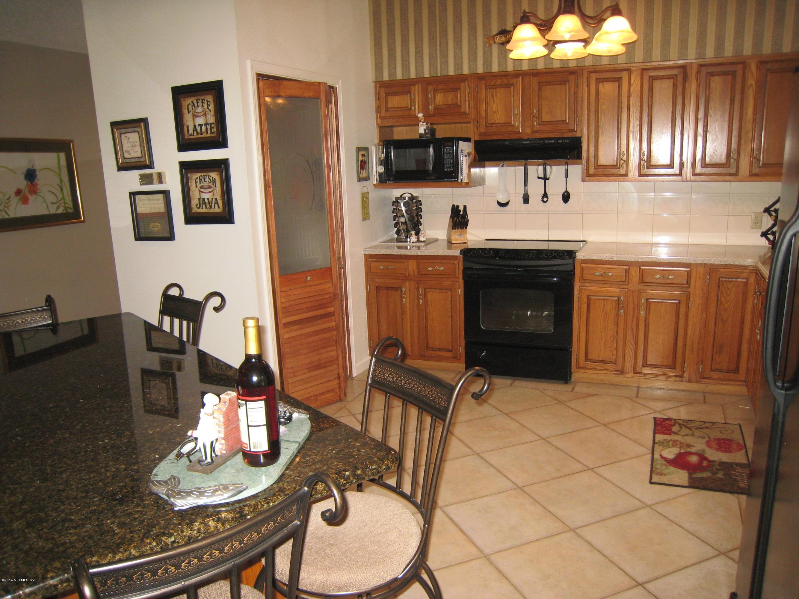 11636 Mandarin Road Jacksonville, FL 32223 - Photo 15 of 41 a kitchen with stainless steel appliances a sink a stove a refrigerator cabinets and dining table