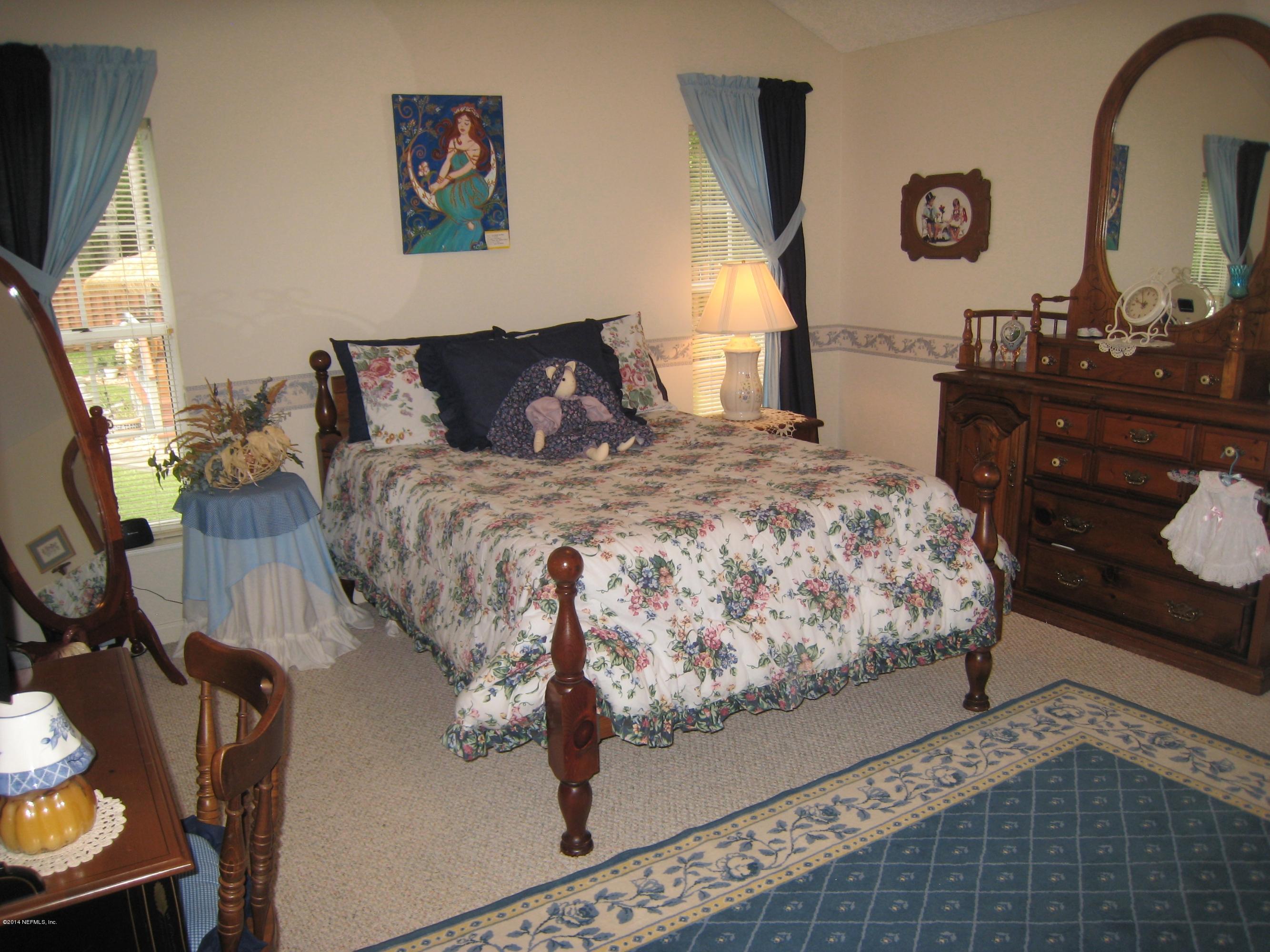 11636 Mandarin Road Jacksonville, FL 32223 - Photo 25 of 41 a bedroom with a bed and wooden floor