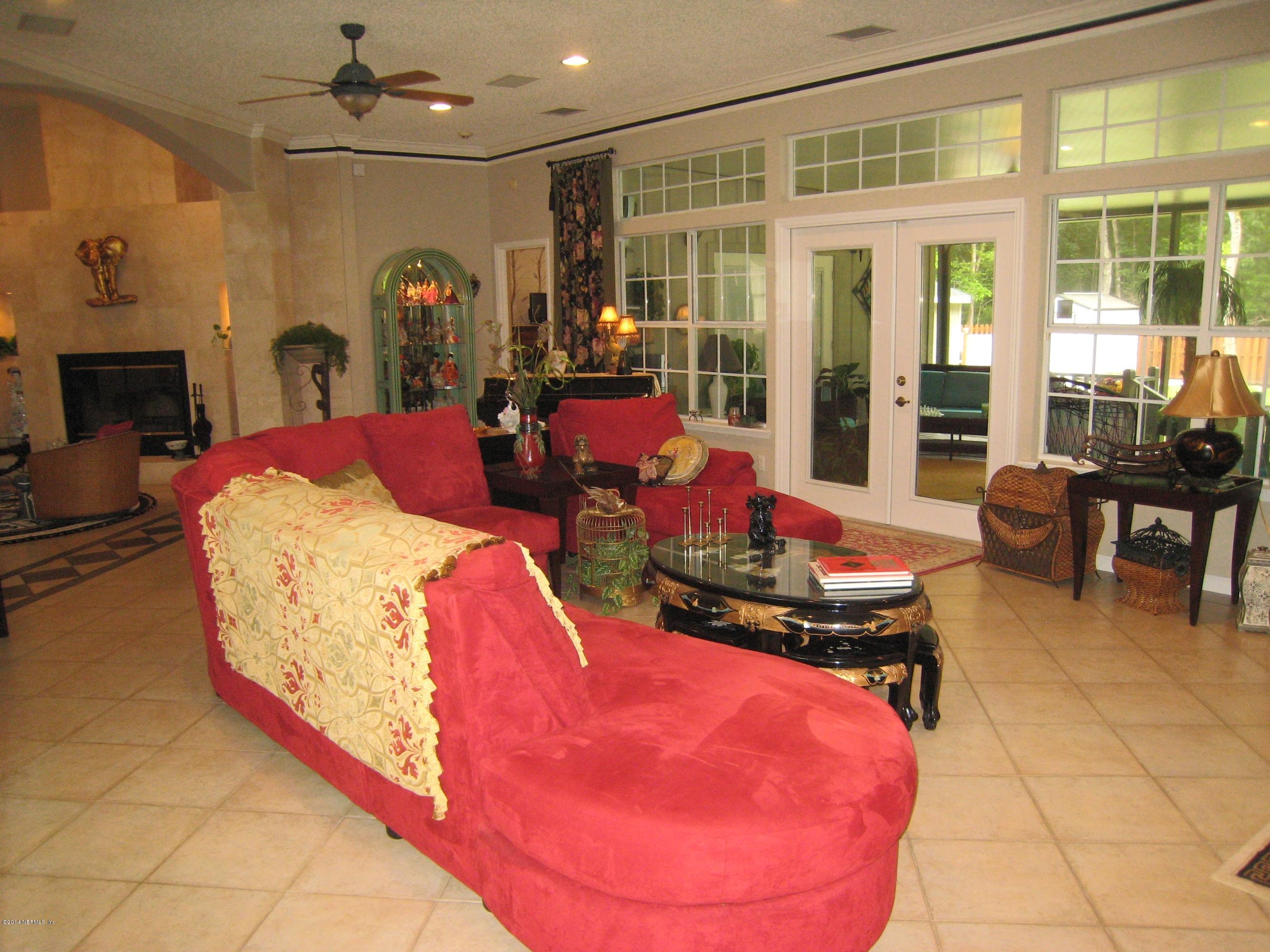 11636 Mandarin Road Jacksonville, FL 32223 - Photo 8 of 41 a living room with furniture a fireplace and a chandelier