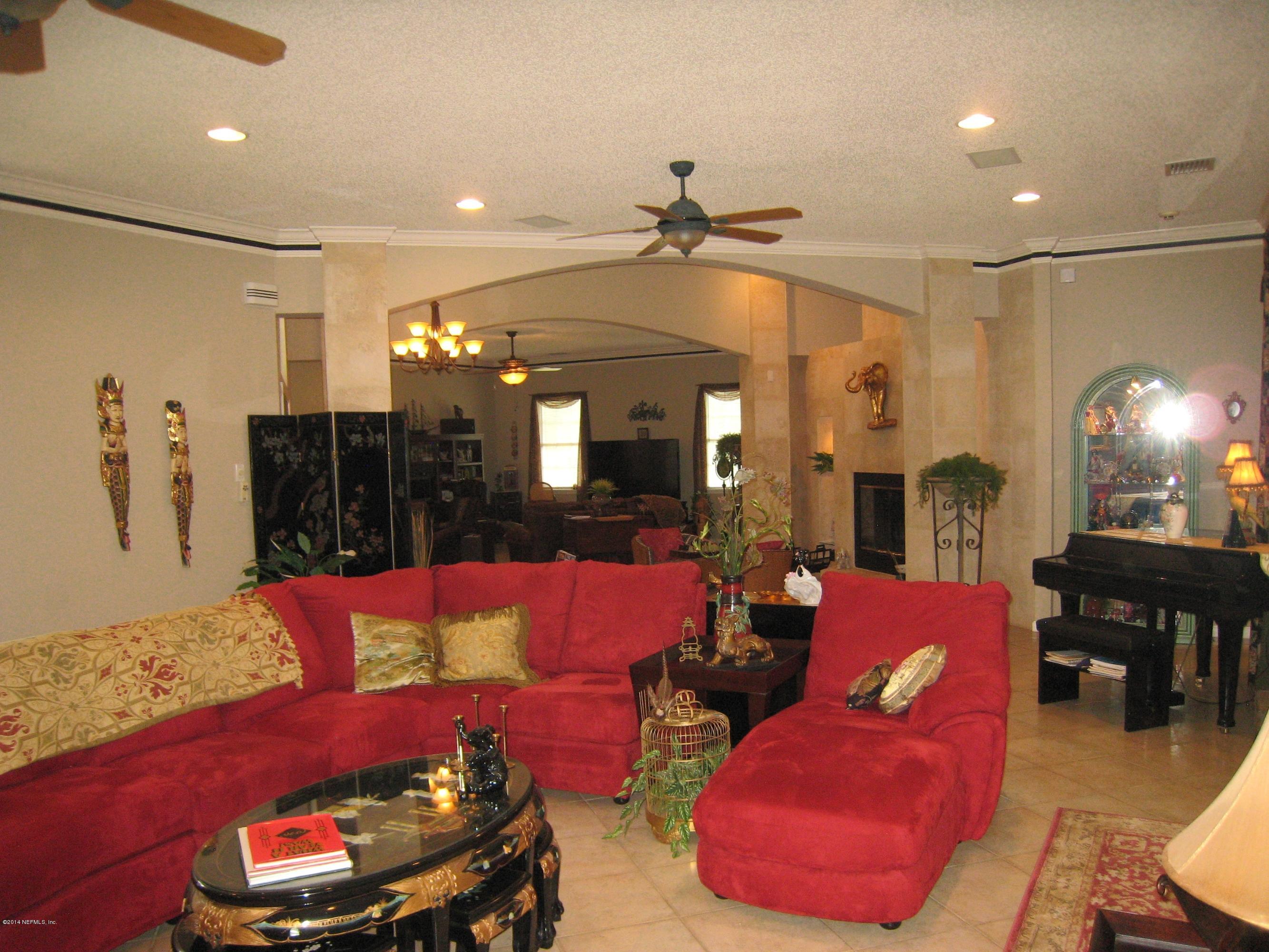 11636 Mandarin Road Jacksonville, FL 32223 - Photo 9 of 41 a living room with furniture a fireplace and a chandelier
