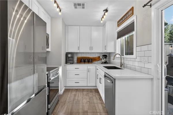 a kitchen with cabinets appliances and a window