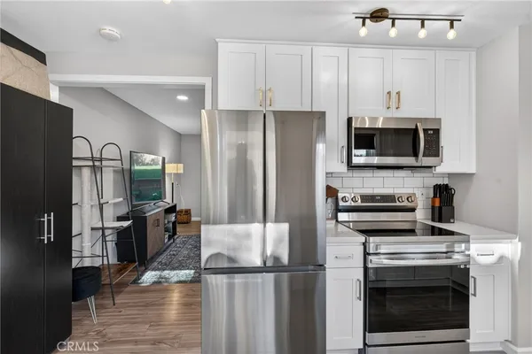 a kitchen with stainless steel appliances a stove microwave and refrigerator