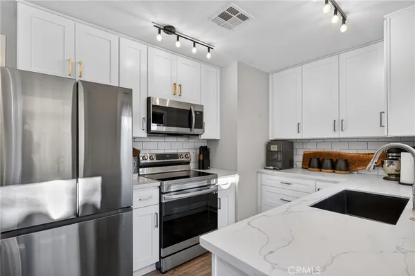 a kitchen with a sink stainless steel appliances and cabinets