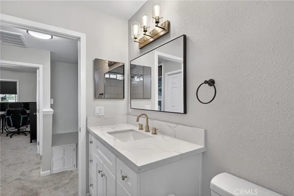 a bathroom with a toilet sink and mirror