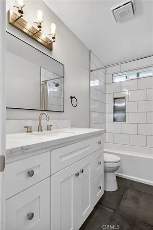 a bathroom with a double vanity sink mirror and toilet