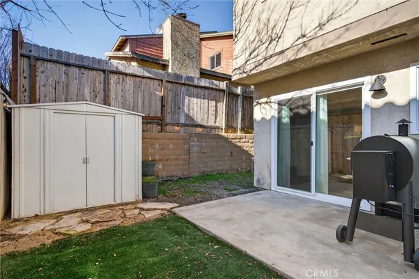 a view of a chair and table in backyard of the house