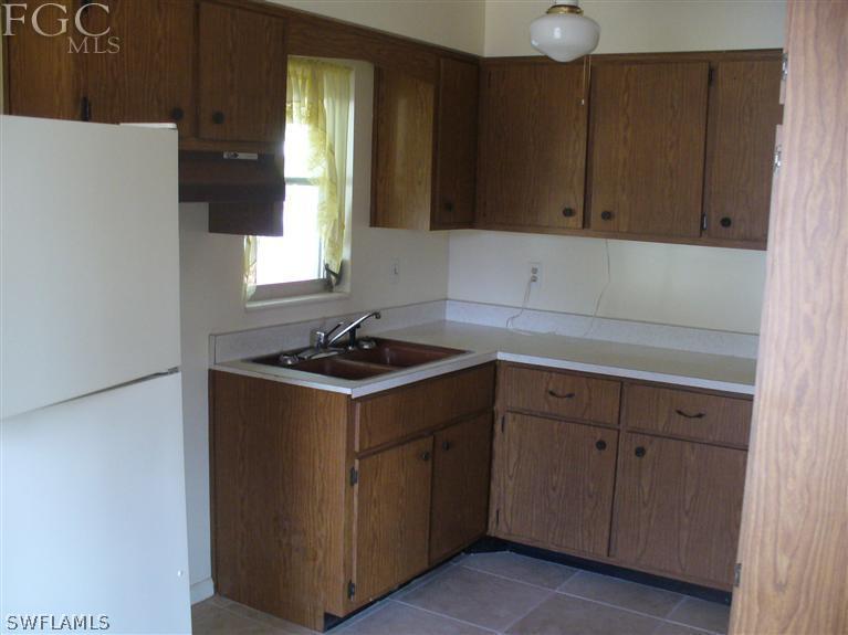 369 Westpark Road Lehigh Acres, FL 33936 - Photo 2 of 7 a kitchen with a sink cabinets and window