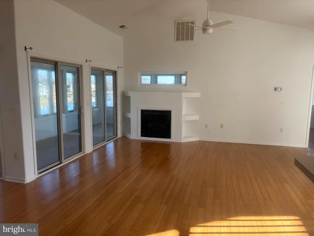 a view of empty room with wooden floor and fireplace