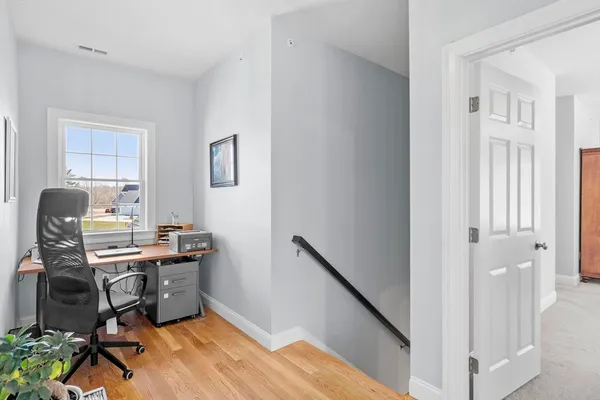 a view of a workspace with furniture and a window