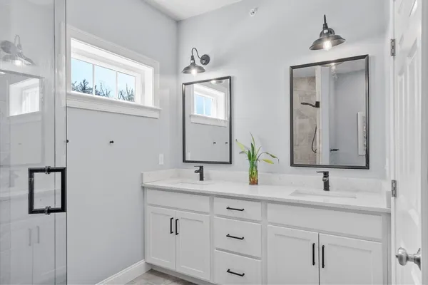 a bathroom with a double vanity sink and mirror