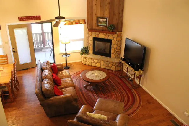a living room with furniture a flat screen tv and a fireplace