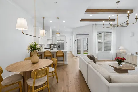 a view of a dining room with furniture a chandelier and wooden floor