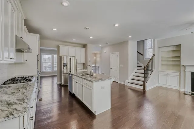a kitchen with stainless steel appliances kitchen island hardwood floor sink and stove