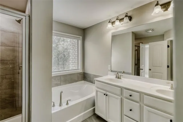 a bathroom with a tub a sink and mirror