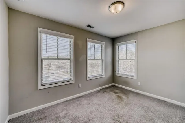 an empty room with windows and closet