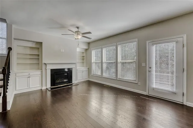 wooden floor fireplace and windows in an empty room