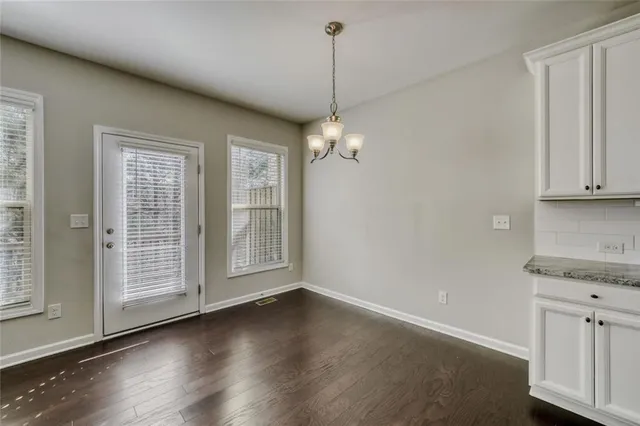 a view of a kitchen with wooden floor and a window