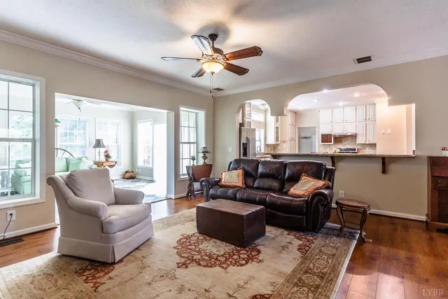 a kitchen with stainless steel appliances granite countertop a stove top oven a sink dishwasher a refrigerator and white cabinets with wooden floor