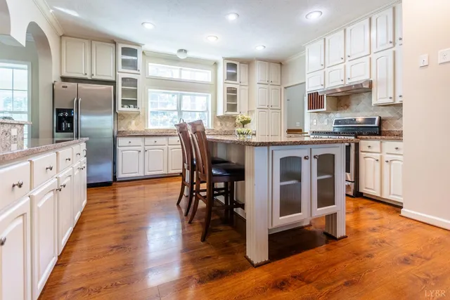 a kitchen with granite countertop a stove top oven and cabinets