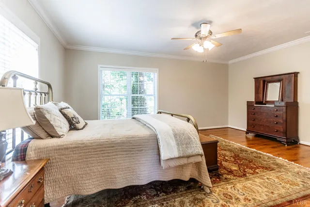 a bedroom with two beds and wooden floor