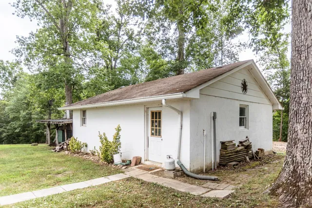 a view of field with tall trees in the background