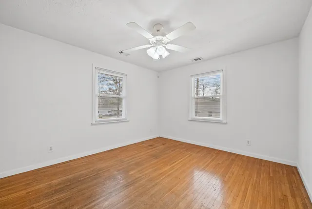 a view of an empty room with wooden floor