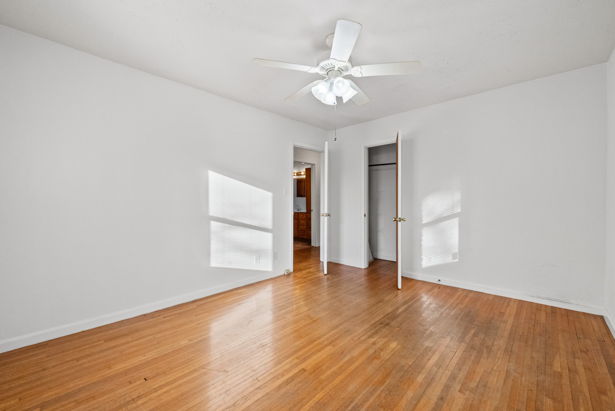 1667 McWhorter Road Cunningham, TN 37052 - Photo 18 of 35 an empty room with wooden floor chandelier fan and windows