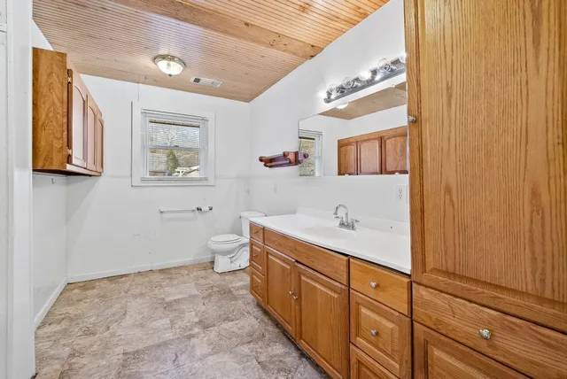 a bathroom with a sink mirror and toilet