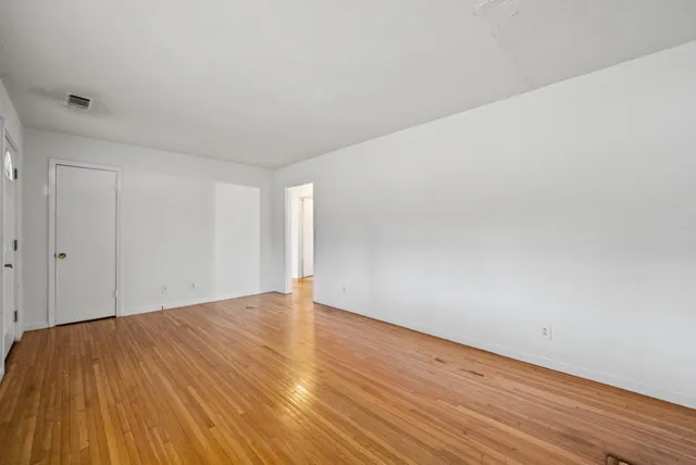 a view of an empty room and wooden floor