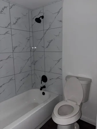 a white toilet and a bathtub in a bathroom