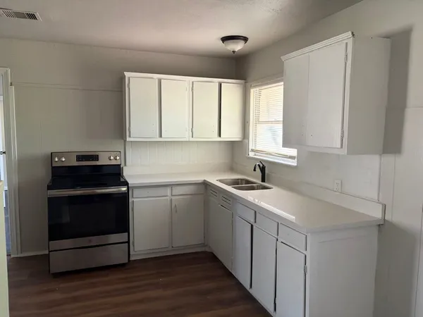 a kitchen with a sink stove and cabinets