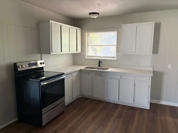 a kitchen with a sink stove and cabinets