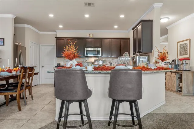 a kitchen with stainless steel appliances a table and chairs