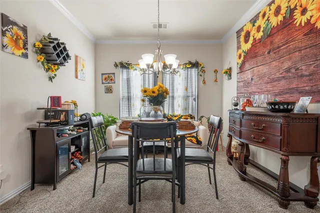 a view of a dining room with furniture and chandelier