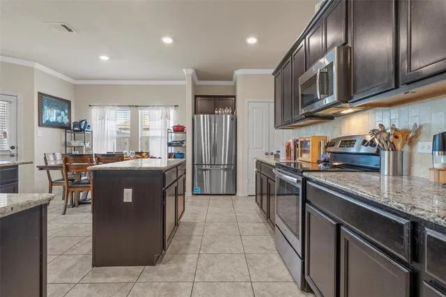 a kitchen with stainless steel appliances granite countertop a sink a stove and a refrigerator