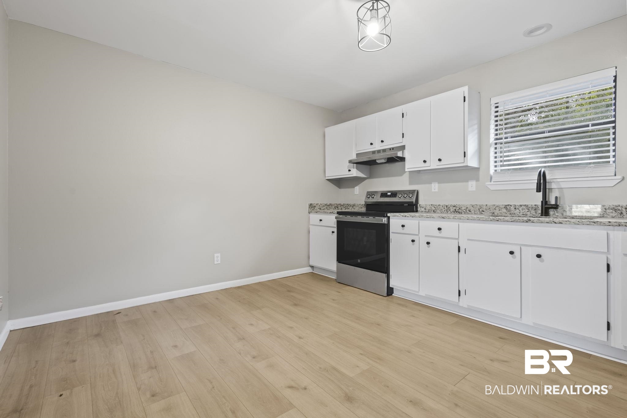 309 West Roosevelt Avenue Foley, AL 36535 - Photo 27 of 60 Kitchen featuring stainless steel range with electric cooktop, sink, light stone countertops, light wood-type flooring, and white cabinetry