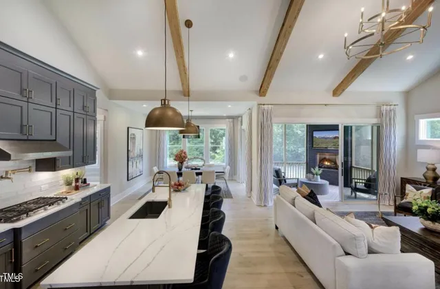 a large kitchen with stainless steel appliances kitchen island granite countertop a lot of cabinets a sink and a refrigerator