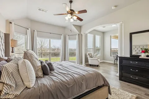 a bedroom with a bed and a large window