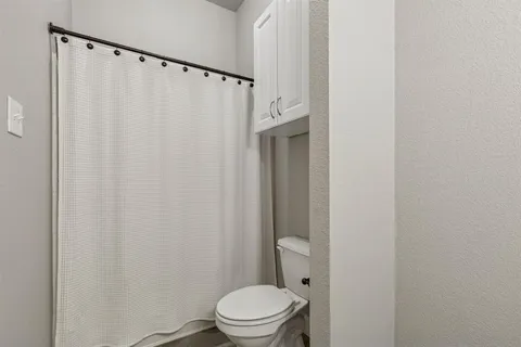a white toilet sitting next to a shower