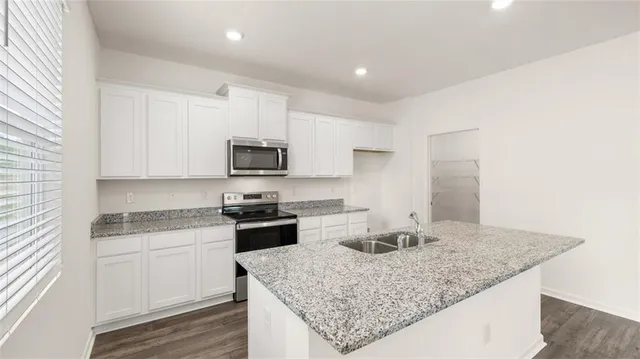 a kitchen with stainless steel appliances granite countertop a sink and a stove