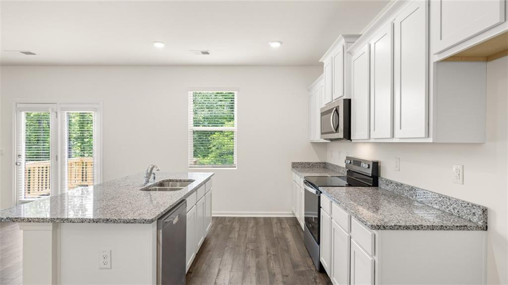 621 Lobelia Way Locust Grove, GA 30248 - Photo 14 of 42 a kitchen with stainless steel appliances granite countertop a sink and a stove