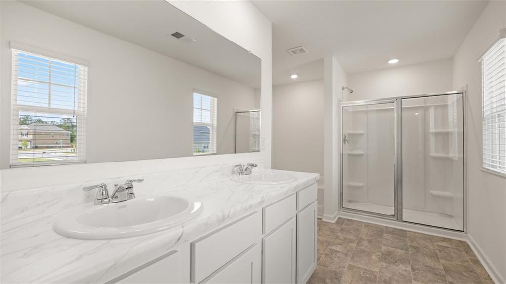 621 Lobelia Way Locust Grove, GA 30248 - Photo 19 of 42 a bathroom with a sink a shower and a mirror