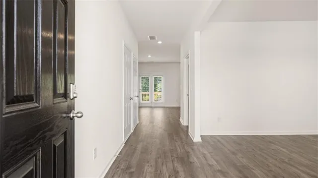 a view of a yard with plants and large trees