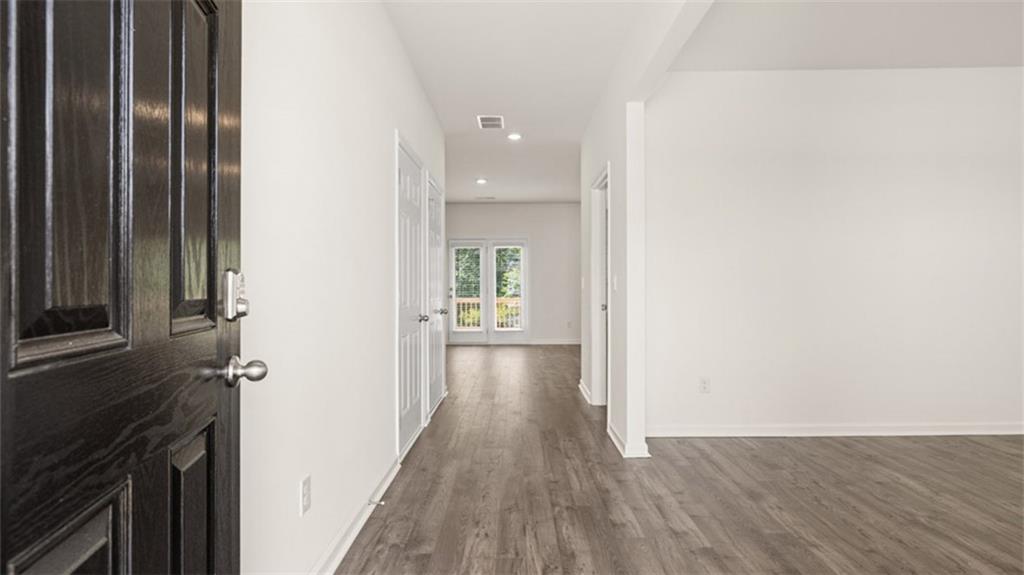 621 Lobelia Way Locust Grove, GA 30248 - Photo 38 of 42 a view of a hallway with wooden floor and staircase