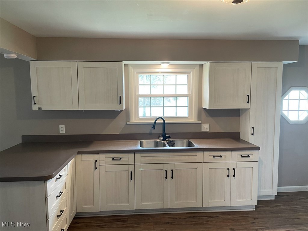 855 Georgetown Road Salem, OH 44460 - Photo 10 of 28 Kitchen featuring baseboards, dark countertops, white cabinets, dark wood-type flooring, and a sink
