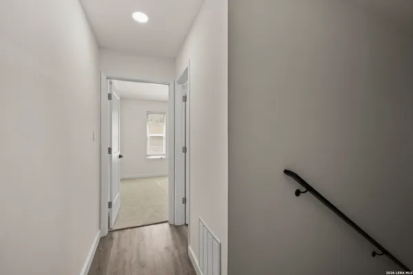 a view of a hallway with wooden floor