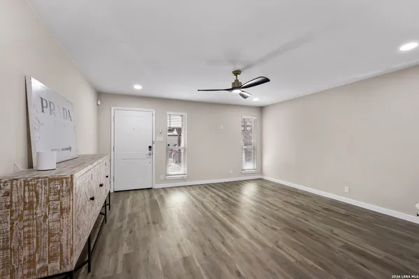 a view of an empty room with wooden floor