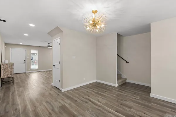 an empty room with wooden floor and entryway