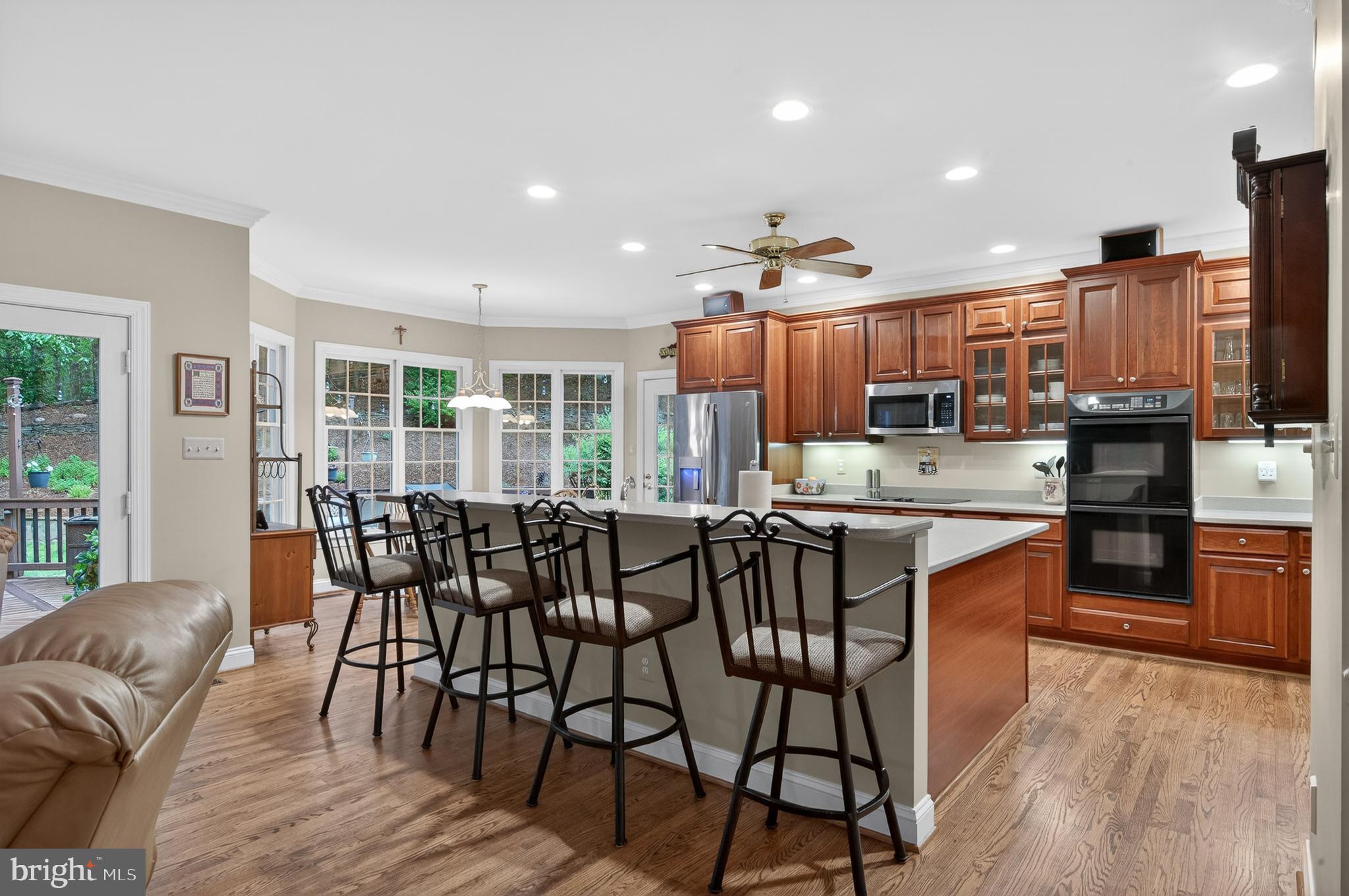 6601 Colchester Road Fairfax Station, VA 22039 - Photo 18 of 78 a kitchen with stainless steel appliances a dining table chairs and wooden floor